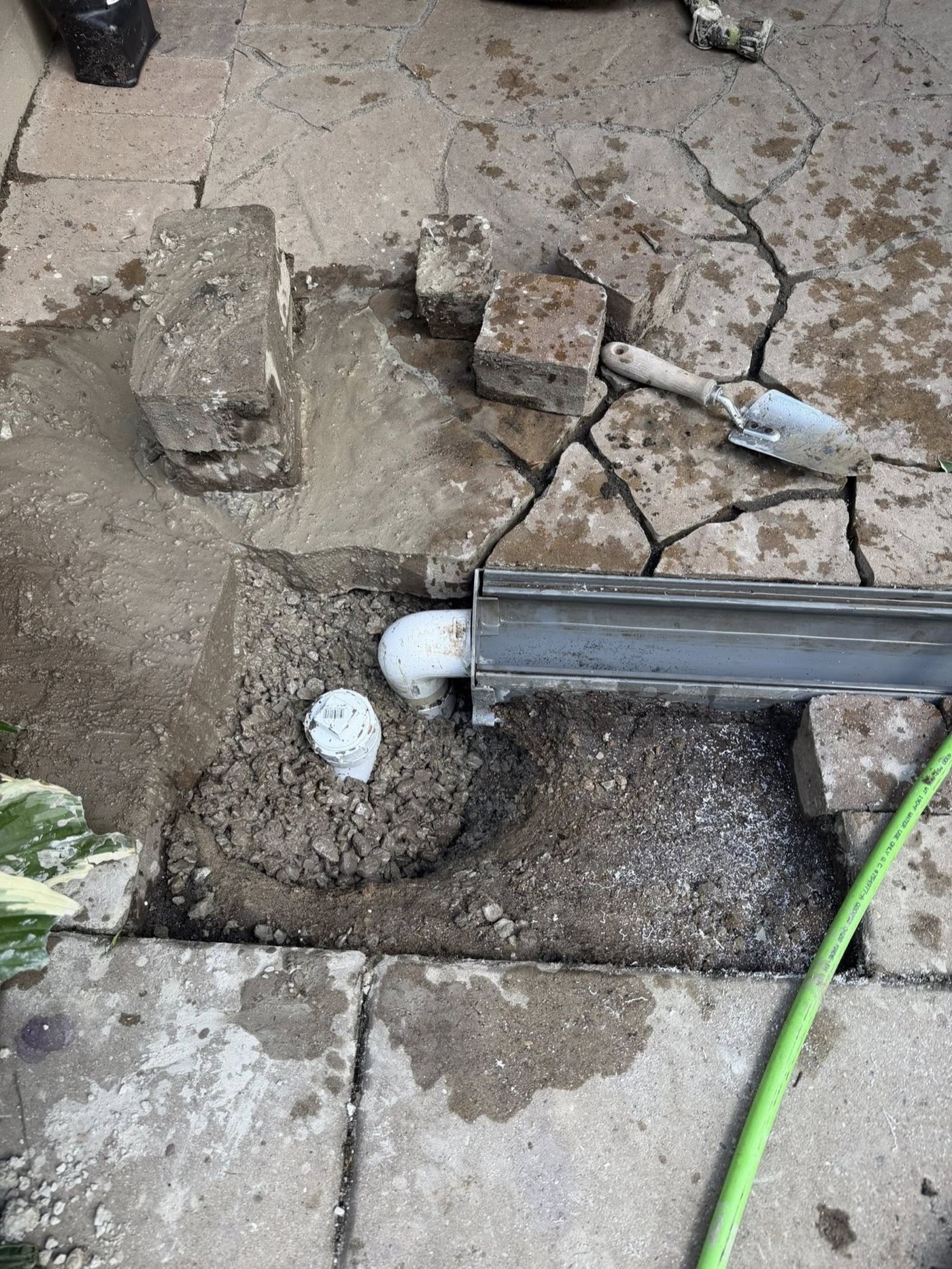 Close-up of the trench drain outlet showing the debris and root mass that was clogging the storm line entry